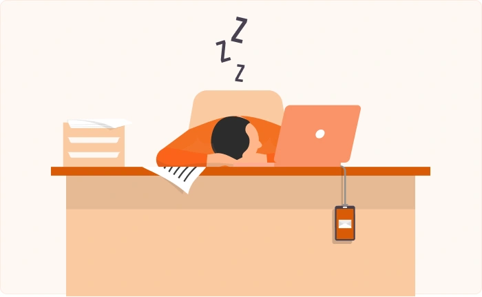 Person sleeping at an office desk next to a laptop.